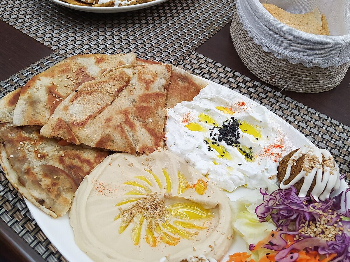 A Lebanese mezze plate: hummus, labneh, falafel and salad with flatbread.