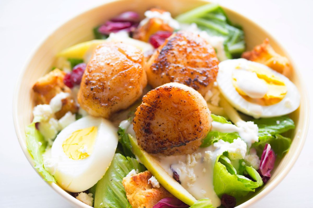 A salad bowl with halved boiled eggs and fresh greens.